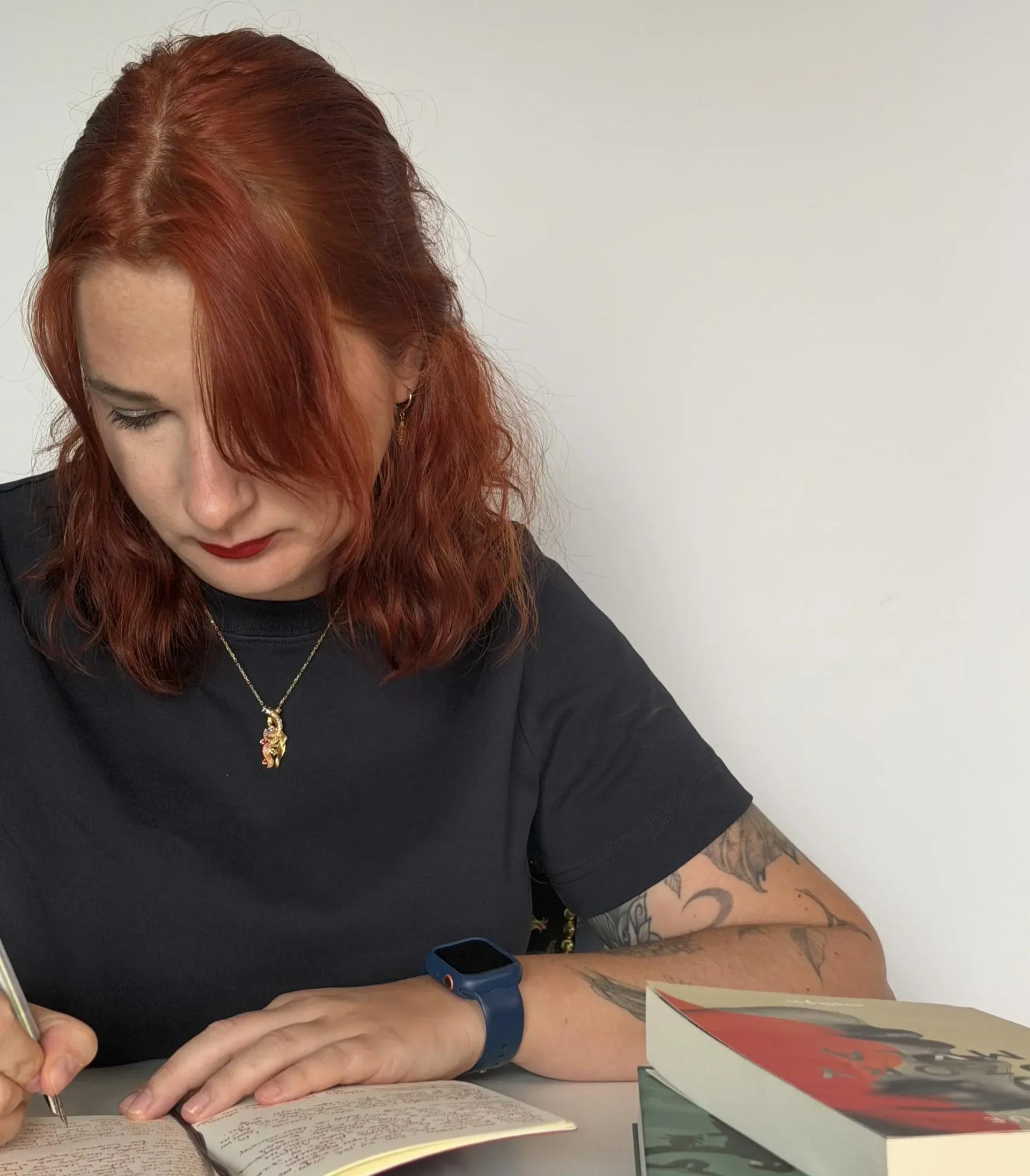 dr Kinga Rak pisze notatki w zeszycie podczas pracy nad książką i redakcji tekstu